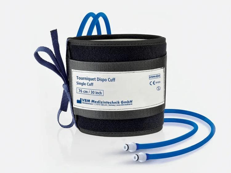 This clinical photograph displays a sterile standard pneumatic (SST) tourniquet cuff designed for surgical use. The device is a black, disposable synthetic fabric cuff featuring a centralized white label. The label identifies the product as a 'Tourniquet Dispo Cuff, Single Cuff' with a specified length of 76 cm (30 inches), and includes manufacturer details for VBM Medizintechnik GmbH. Regulatory and safety symbols are present on the label, including the 'STERILE EO' mark indicating ethylene oxide sterilization, a 'CE 0123' conformity mark, and a 'do not reuse' (single-use) icon. Integral to the pneumatic system, two blue inflation tubes extend from the base of the cuff, terminating in white and gray luer-lock style connectors for attachment to a pressure regulator. A dark blue fabric fastening strap is attached to the lateral side for securing the cuff around a patient's limb. This equipment is primarily used in orthopedic surgery to create a bloodless operative field by occluding distal blood flow.