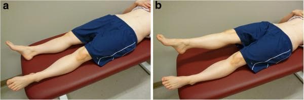 Two side-by-side clinical photographs (labeled 'a' and 'b') demonstrating the Active Straight Leg Raise (ASLR) test, a common clinical assessment used in orthopedics and physical therapy to evaluate pelvic girdle stability and lumbopelvic motor control. In panel (a), the participant is shown in the starting position, lying supine on a padded examination bench with both lower extremities fully extended and resting on the surface. In panel (b), the participant performs the active phase of the test by elevating the right leg while maintaining knee extension, approximately 20 cm above the bench, while the left leg remains stationary and in contact with the surface. The images focus on the lower body, illustrating the hip flexion and stabilization required during the maneuver. This visual serves as a standardized protocol guide for clinicians assessing functional movement, sacroiliac joint dysfunction, or low back pain. The subject is shown from a posterolateral perspective, emphasizing the mechanics of the hip and pelvic region during unilateral limb movement.