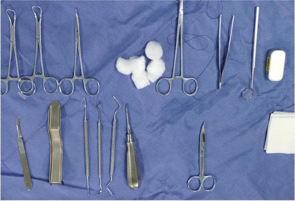 A top-down clinical photograph displays a standardized preoperative surgical tray for an oral and maxillofacial procedure, specifically a third molar extraction. The instruments are arranged on a sterile blue surgical drape. Visible metallic instruments include towel clamps (Backhaus), various hemostatic forceps (mosquito or Kelly style), and needle holders, one of which is loaded with a black silk or synthetic suture. Specialized dental instruments include a periosteal elevator, dental explorers, a mouth mirror, and a straight root elevator with a thick ergonomic handle. Additionally, a surgical scalpel with a #15 blade and a pair of curved Iris or Metzenbaum-style scissors are present. Consumable supplies include several cotton wool rolls and a stack of folded sterile gauze pads. The set demonstrates the essential armamentarium for achieving flap reflection, bone removal, tooth sectioning, and soft tissue closure in dental surgery.