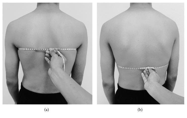 This clinical photograph illustrates the standardized procedure for measuring chest expansion (CE) using a tape measure on a human subject in a standing position. The image is divided into two panels: (a) Upper chest expansion measurement, where the measuring tape is positioned at the level of the fifth thoracic vertebra (T5) posteriorly, crossing the mid-clavicular line and the third intercostal space anteriorly. (b) Lower chest expansion measurement, showing the tape aligned with the 10th thoracic vertebra (T10) posteriorly and the xiphoid process anteriorly. In both panels, an examiner's hand is visible securing the '0' point of the tape measure against the midline of the spine using the index finger to ensure stability and accuracy during respiratory cycles. This technique is used in clinical physical therapy and pulmonary assessments to quantify thoracic mobility and assess lung function parameters such as FEV1 and FVC. The visual emphasizes correct anatomical landmark alignment for reproducible measurement of inspiratory and expiratory thoracic diameter changes.