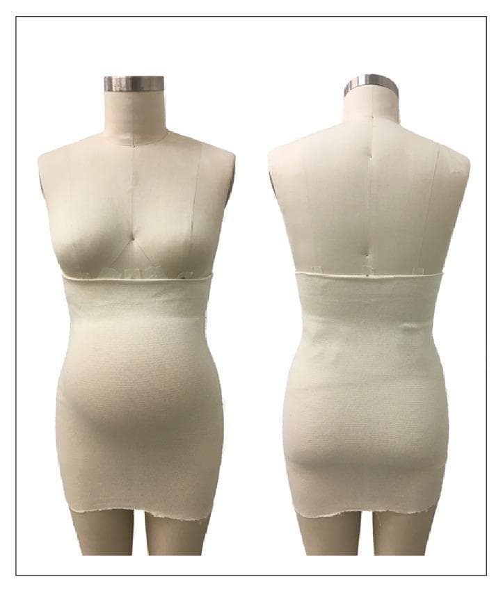 This clinical photograph displays a front and back view of a Tubigrip elastic support garment fitted on a female mannequin representing a pregnant torso. The garment is an elastic, one-piece tubular band with a ribbed texture, indicating a knit fabric construction. It is designed without fasteners or seams for a form-fitting, snug application. Anatomically, the band begins just below the inframammary fold and extends inferiorly to the mid-thigh level, covering the entire abdominal and pelvic regions. The visual demonstrates how the material conforms to the body's contours, specifically the protruding gravid abdomen and the lower back/lumbar region. In an obstetric and musculoskeletal context, such garments are used for the management of pregnancy-related low back pain (LBP) and pelvic girdle pain (PGP). The educational focus is on the distribution of circumferential compression to provide abdominal support, stabilize the pelvic area, and potentially reduce mechanical strain on the symphysis pubis and sacroiliac joints during pregnancy.