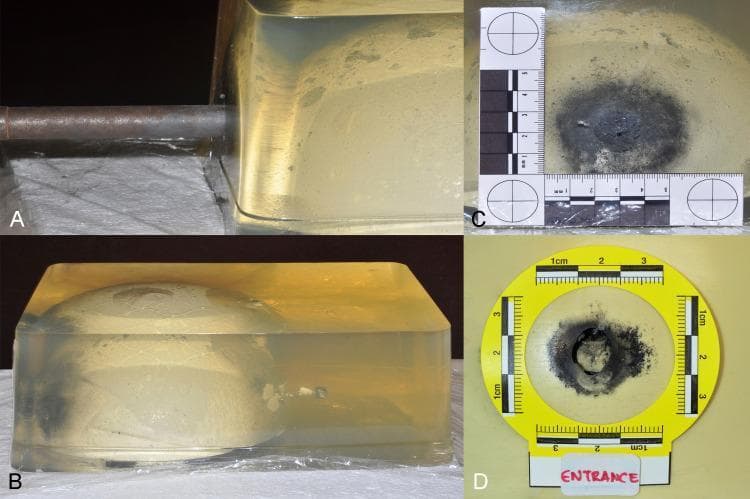 This forensic pathology experimental image set demonstrates a ballistics reconstruction of a penetrating gunshot wound using a gelatin-based head model with an embedded synthetic bone structure. Frame A shows a contact-range test shot being fired into the model using a handmade firearm. Frame B provides a lateral profile of the ballistic gelatin block, revealing a linear projectile trajectory from left to right; a permanent wound cavity is visible, which is widest near the entry point and tapers toward the exit, representing energy dissipation and tissue displacement. Frames C and D are close-up views of the entrance wound on the gelatin surface and the underlying bone model, respectively. Both detail a central circular defect surrounded by extensive, dark, irregular soot deposition and charring, characteristic of a contact-range discharge. Each frame includes forensic scaling and labeling to quantify the diameter of the soot pattern and the projectile entrance. This model serves as a simulation for cranial ballistics, demonstrating the relationship between muzzle distance and forensic markers like soot deposition and internal beveling.