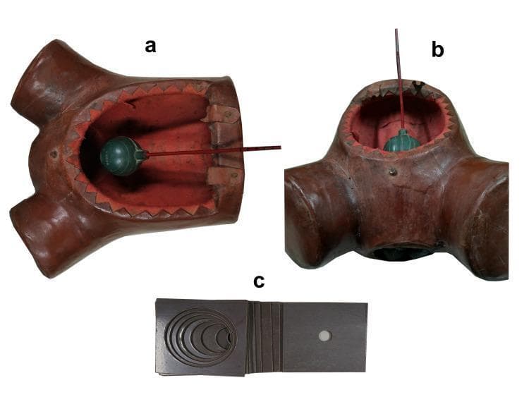This composite image illustrates a three-part medical simulation training model designed for obstetric education, specifically for teaching cervical dilatation and fetal station assessment. Panels (a) and (b) show a female pelvic mannequin torso with an open abdominal aperture. Inside the pelvic cavity, a green spherical component represents the fetal head, attached to a graduated red rod. The rod features 1 cm markings to simulate and measure 'fetal station' relative to internal palpable landmarks (ischial spines). Panel (c) displays a set of dark, rectangular bakelite plates used to simulate the cervix. These plates feature central circular openings ranging from 1 to 10 cm in diameter, allowing trainees to practice digital vaginal examinations to determine cervical dilatation. The model serves as a low-cost, effective tool for labor and delivery simulation, enabling learners to develop tactile skills in assessing the progression of labor within a standardized clinical context.