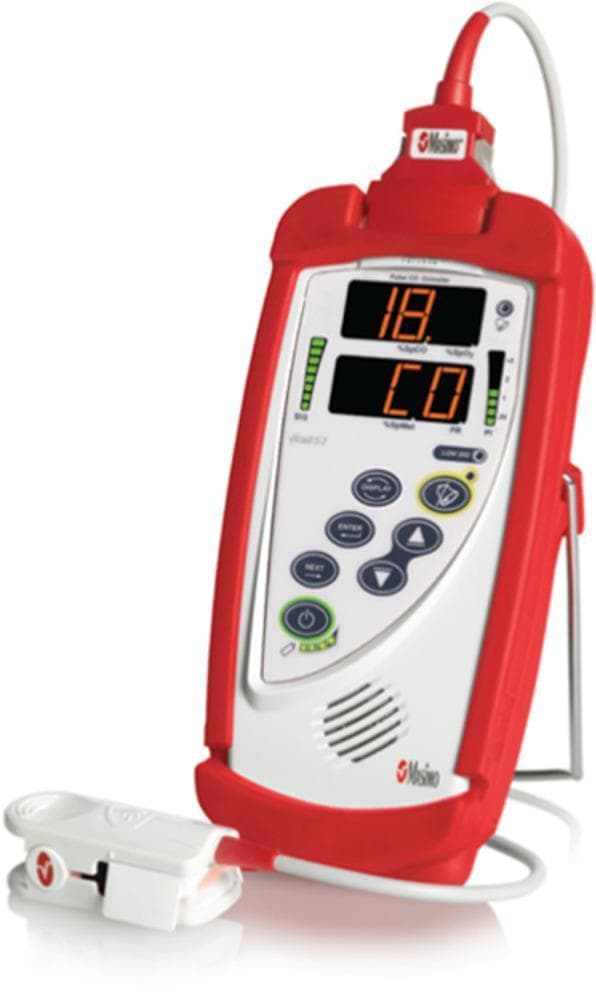 A clinical photograph of the Masimo Rad-57 Pulse CO-Oximeter, a handheld diagnostic device designed for the non-invasive measurement of carboxyhemoglobin (SpCO) and peripheral oxygen saturation (SpO2). The device is encased in a protective red rubberized sleeve and features a prominent LCD digital display. The screen currently indicates a carboxyhemoglobin value of '18' alongside the label 'CO', suggesting a case of carbon monoxide exposure. Flanking the screen are vertical bar graphs for signal strength (SIQ) and plethysmographic variability. The interface includes tactile control buttons for power, navigation (ENTER, NEXT), and display settings. A reusable finger sensor clip is connected via a cord, illustrating the bedside application for rapid screening in emergency medicine, pre-hospital care, and occupational health settings. This tool is critical for the early detection of carbon monoxide poisoning, which can present with non-specific clinical symptoms.