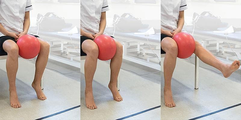 This sequence of clinical photographs demonstrates a rehabilitative exercise for strengthening the vastus medialis oblique (VMO) muscle, often prescribed for synovial plica syndrome or patellofemoral pain. The patient is shown in a seated position on the edge of a clinical plinth with hips and knees at approximately 90 degrees of flexion. A soft medicine ball is placed between the knees. The exercise progression involves three phases: (1) Initial seated posture with feet flat on the floor; (2) Active adduction of the hips to compress the ball, stabilizing the knee joint; and (3) Unilateral knee extension while maintaining adductor tension on the ball. This combination of hip adduction and terminal knee extension specifically targets the VMO to improve patellar tracking and medial quadriceps strength. The visual sequence serves as an educational guide for physical therapy protocols, emphasizing controlled movement and specific muscle recruitment in the management of anterior knee compartment pathologies.